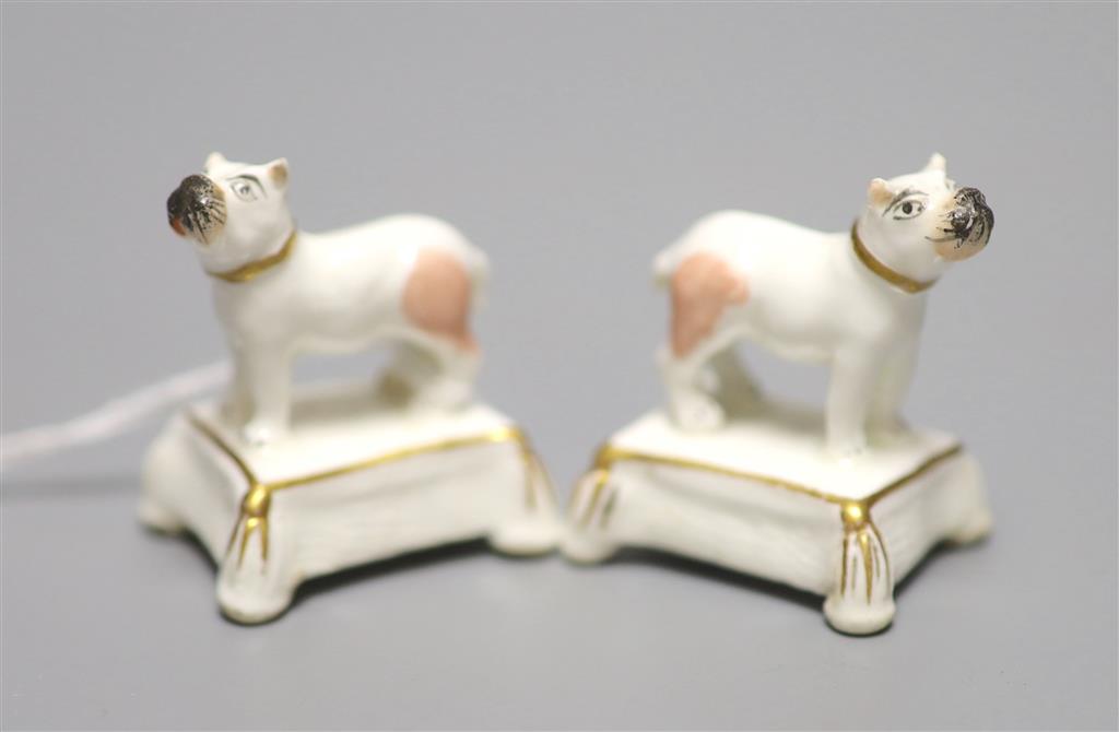 A pair of miniature Staffordshire porcelain pugs, on tassled cushion bases, c.1840, height 3.5cm